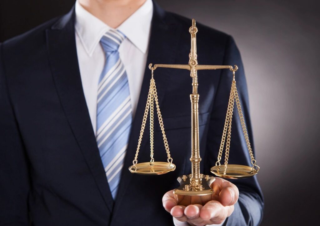 Businessman holding a brass scale of justice